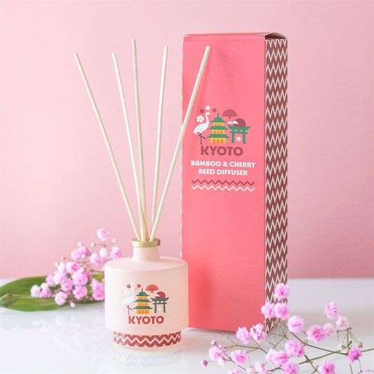 Reed diffuser with 'Kyoto' branding on a pink background