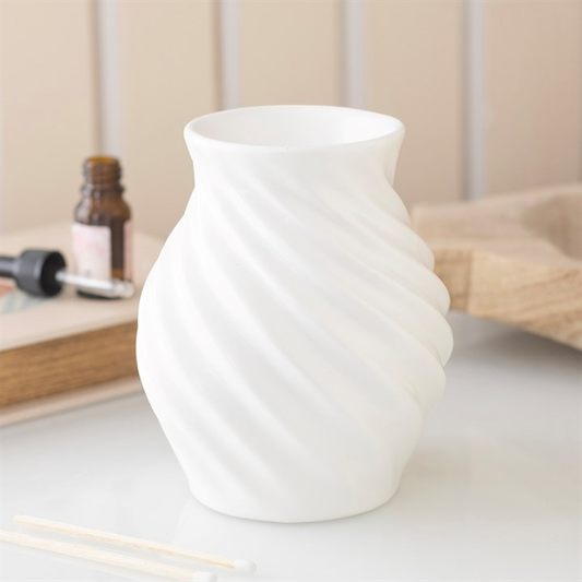 White textured Wax Warmer on a light surface with a blurred background