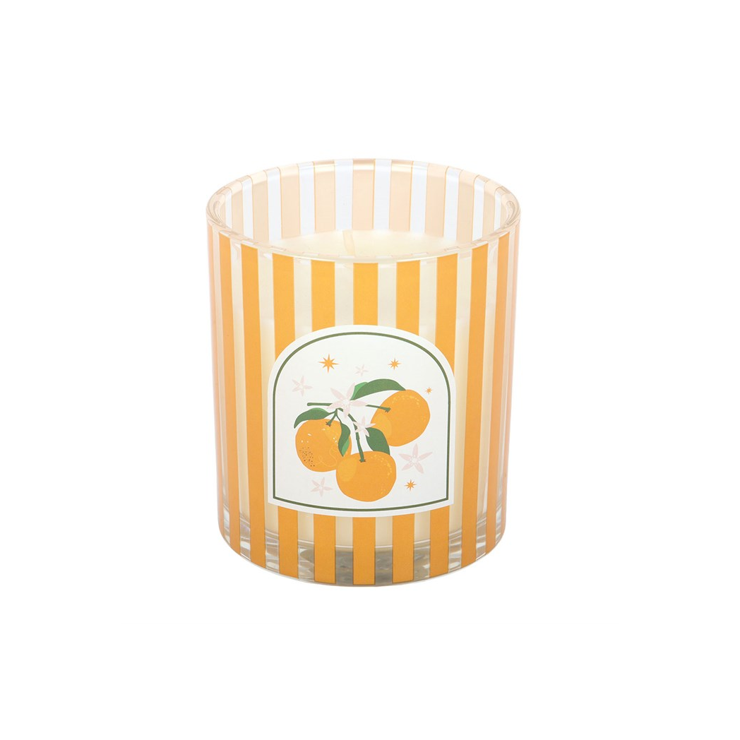 Candle in a striped glass container with an orange design on a white background
