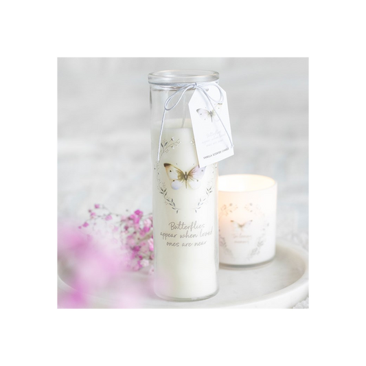 Candle in a glass jar with a butterfly design and tag, on a white background