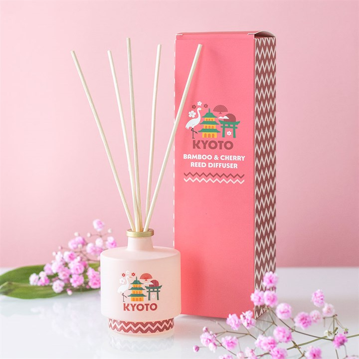 Reed diffuser with 'Kyoto' branding on a pink background