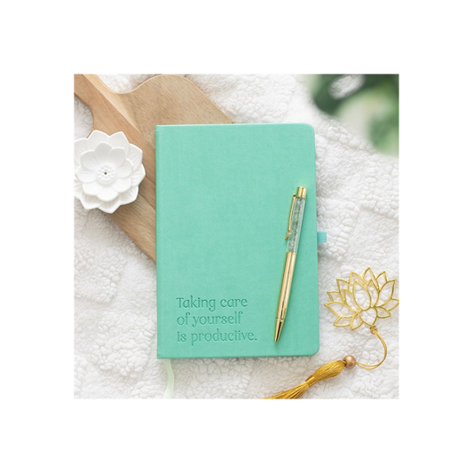 Mint green notebook with a pen on a textured surface with decorative elements.