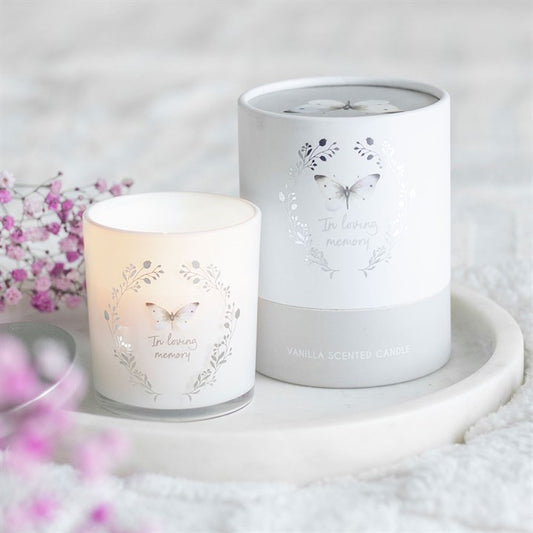 Candle and its packaging with butterfly designs on a soft background