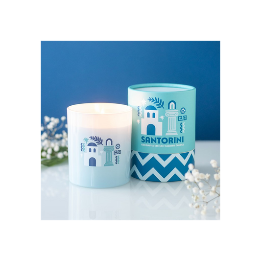 Candle and decorative container with Santorini design on a white surface with blue background